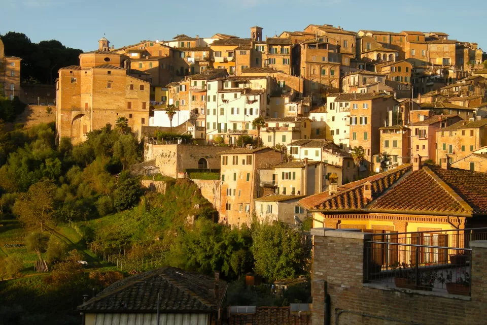 The city of Siena in Italy, located on a hillside and bathed in Tuscan sunlight.